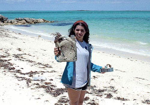 woman at the beach holding plastic